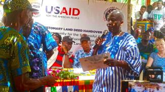 Fessibu CLDMC Chairperson receiving making remark after receiving their Customary Land deed